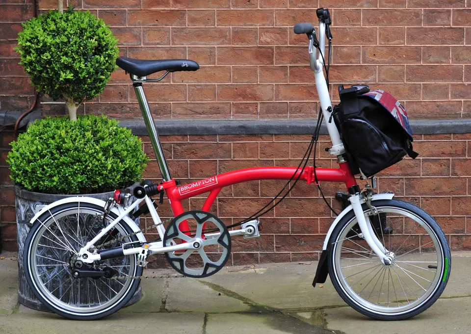Ähnliches rotes Brompton-Faltrad als Kontext für den rekonstruierten Kettenschutz